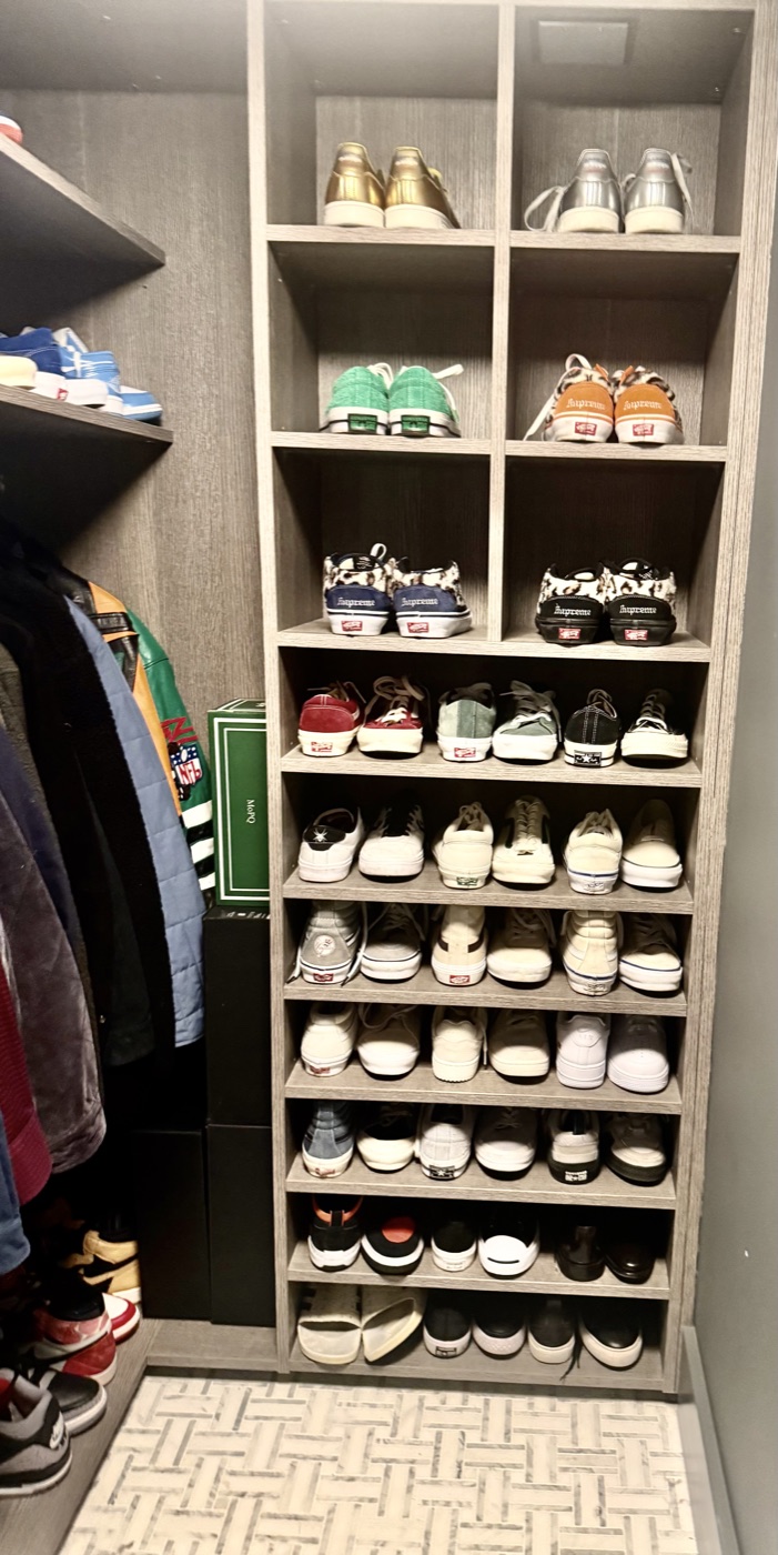 Men's sneaker collection displayed on open shelving