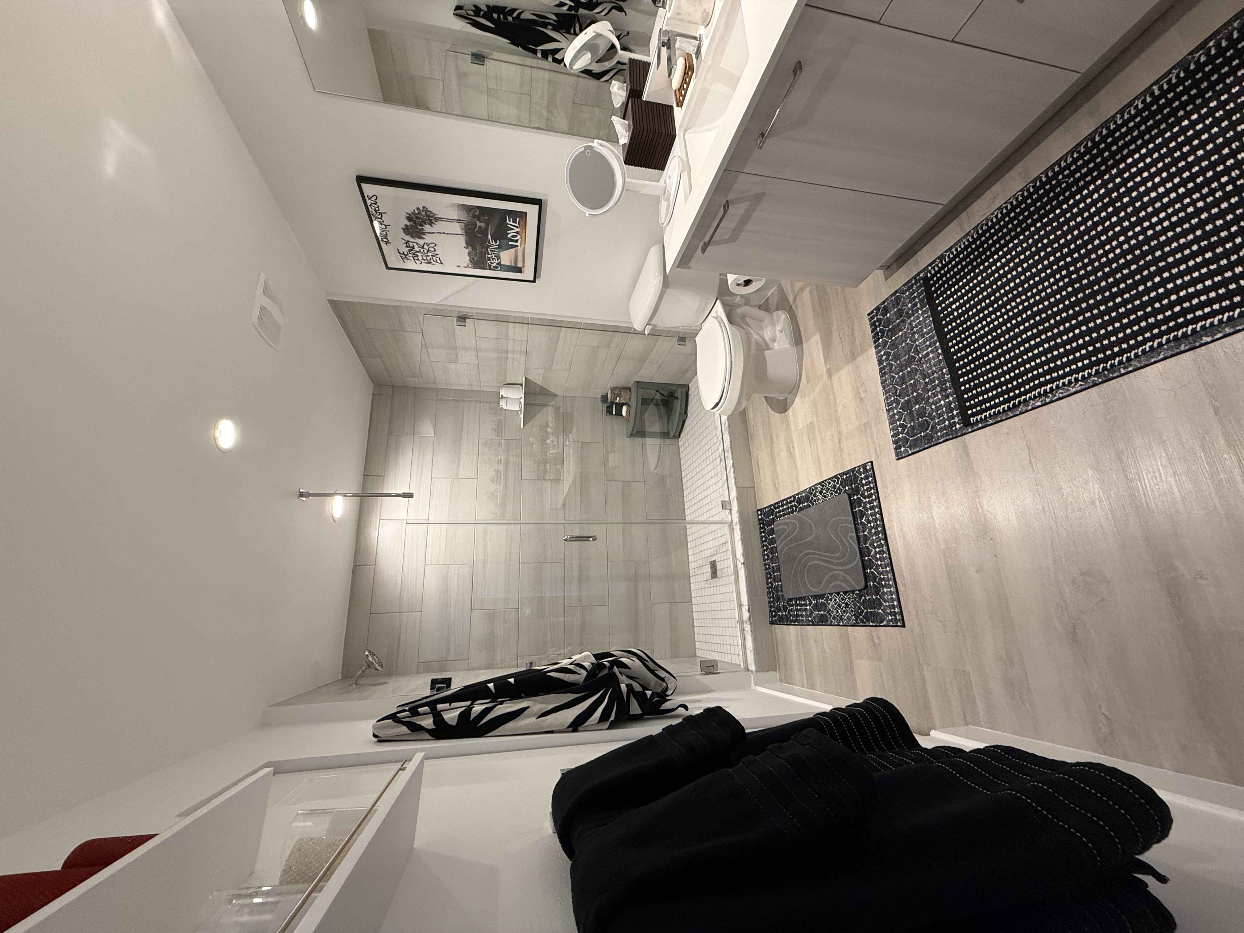 Primary bathroom with folded towels, glass shower, and styled decor