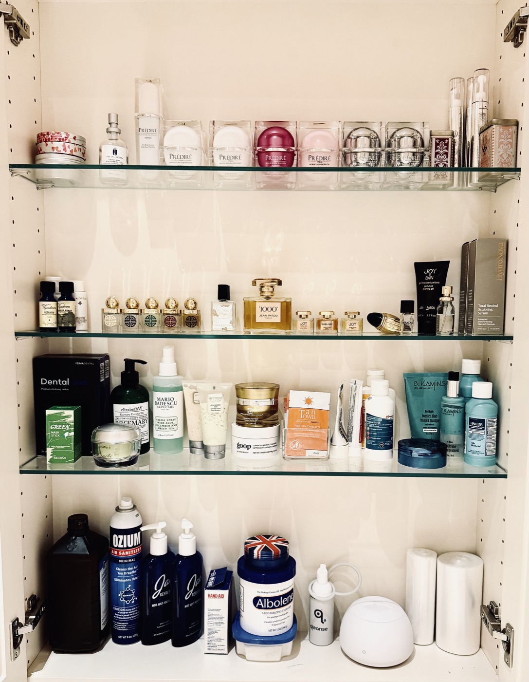 Glass-shelf medicine cabinet with skincare and fragrance collection