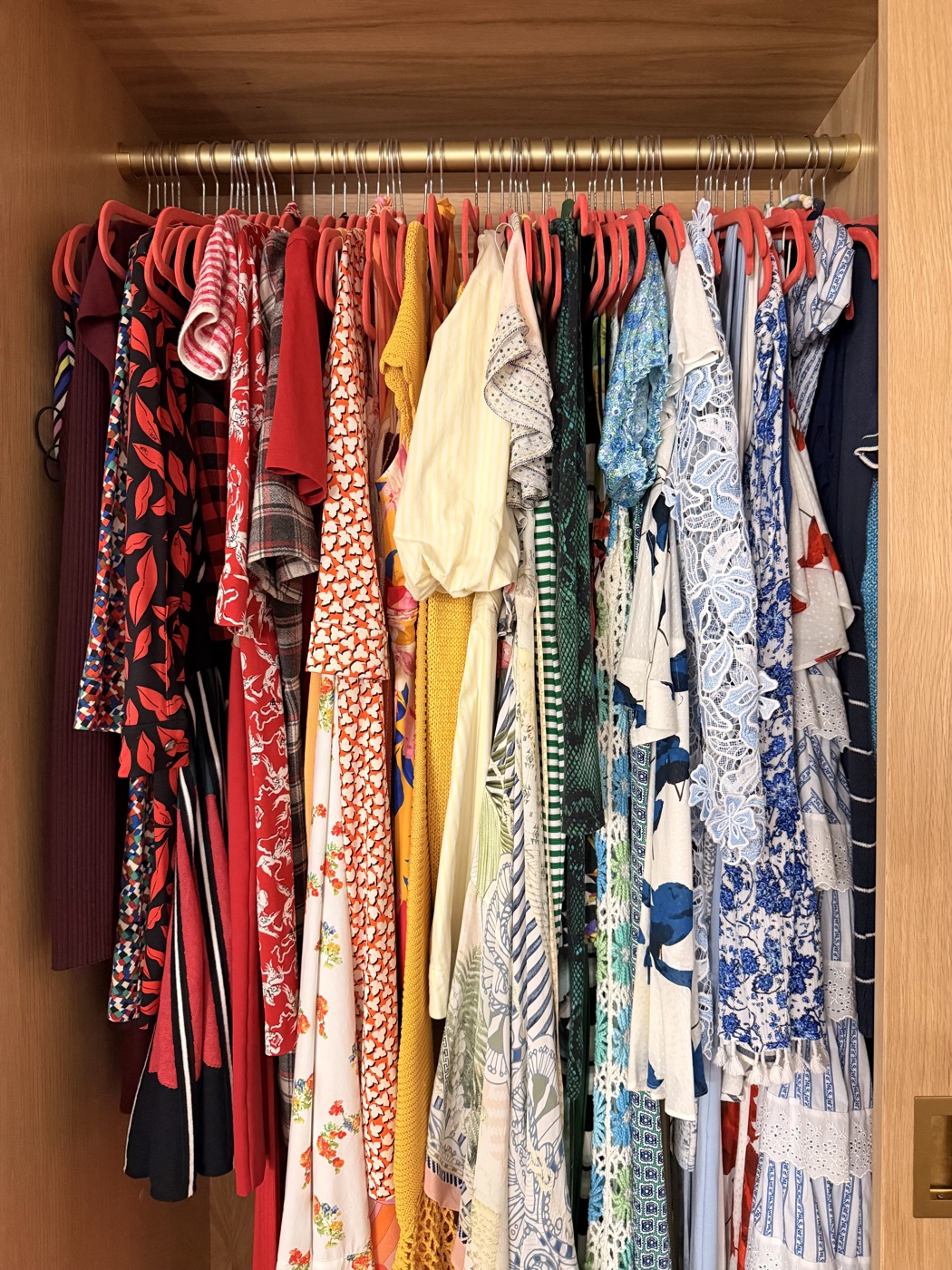 Color-coordinated women's wardrobe with vibrant hanging dresses