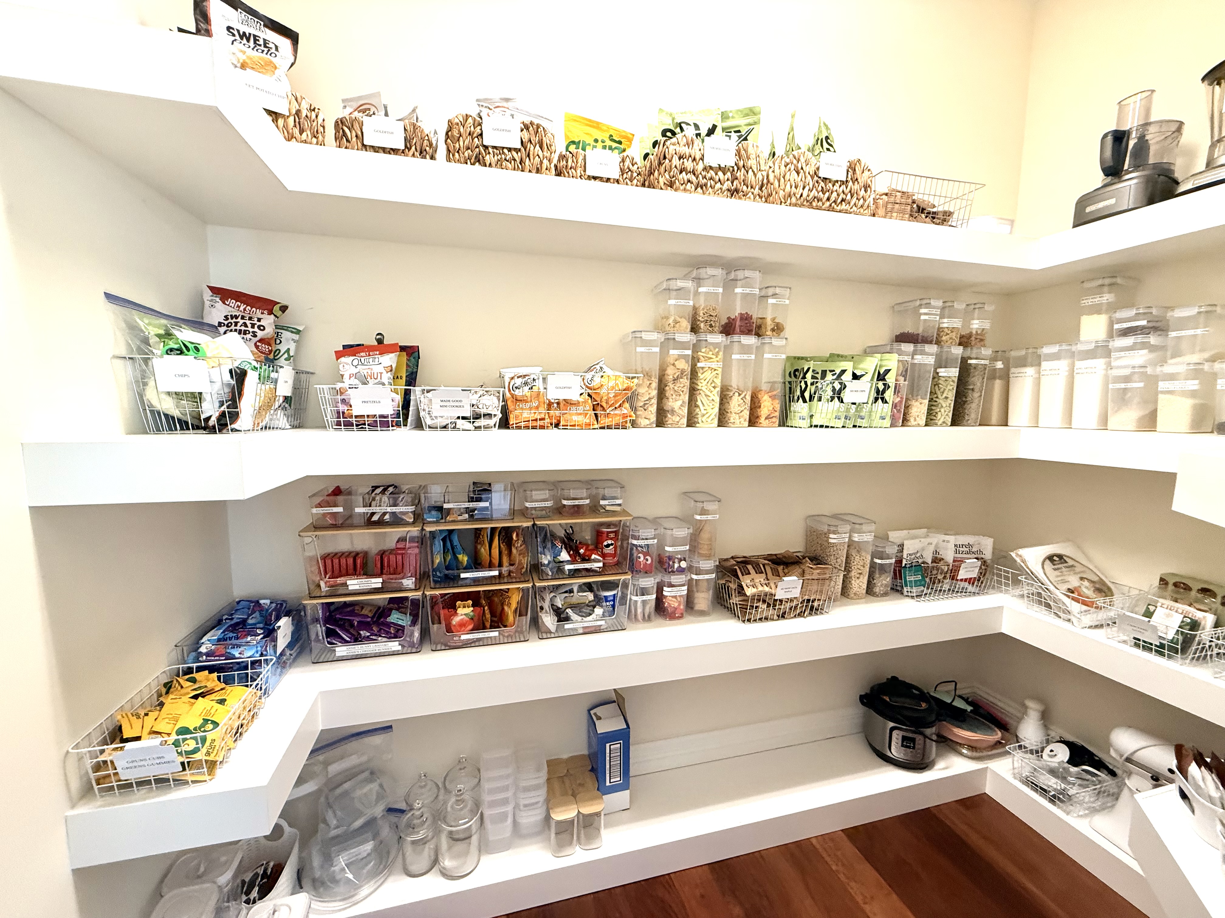 Pantry with labeled bins and clear containers for snacks and pantry staples
