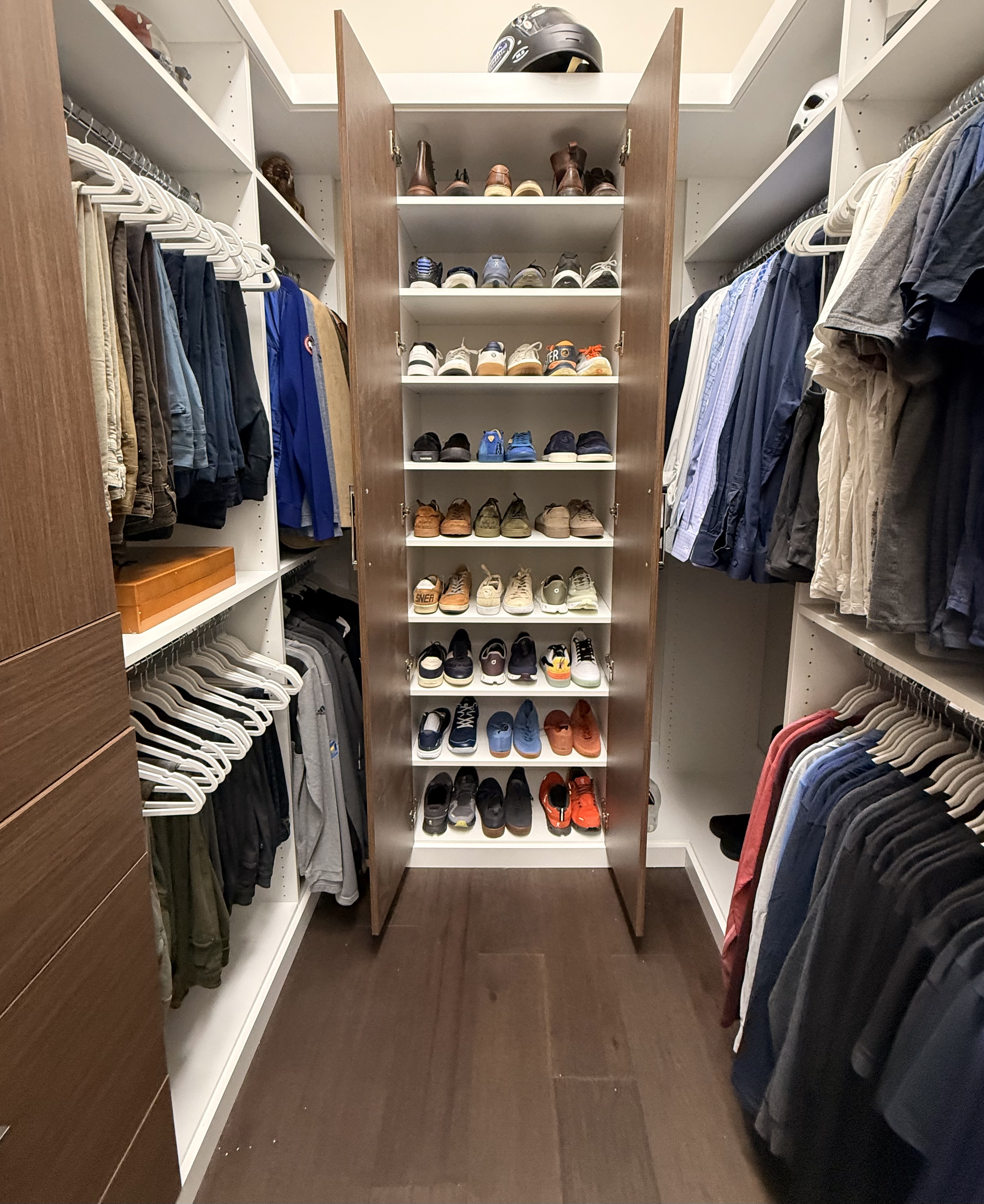 A beautifully organized walk-in closet with floor-to-ceiling shoe shelving
